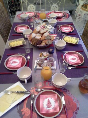 a table with red and white plates and food on it at Le Coq En Pate in Péronne