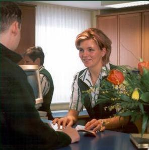 Una donna seduta a un tavolo che parla con un uomo di ARC Hotel a Dieskau