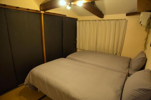 a small bedroom with two beds and a couch at Minkago 鹿児島駅前 #KG1 in Kagoshima
