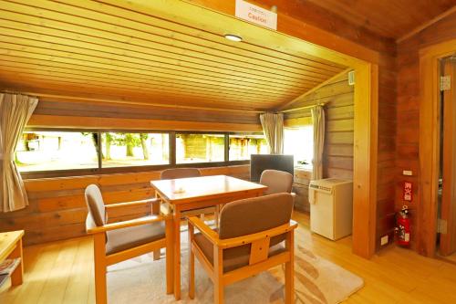 a dining room with a table and chairs and a window at Karuizawa Prince Hotel West in Karuizawa