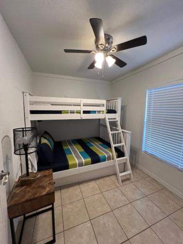 a bedroom with a bunk bed with a ceiling fan at Short Walk to Beach 1 in South Padre Island