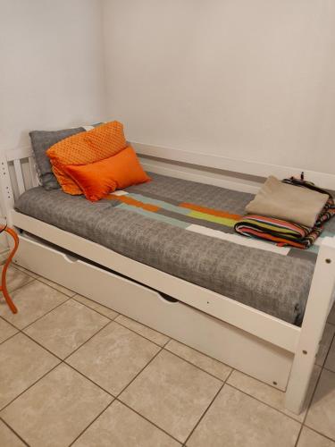 a bed with an orange pillow on top of it at Short Walk to Beach 1 in South Padre Island