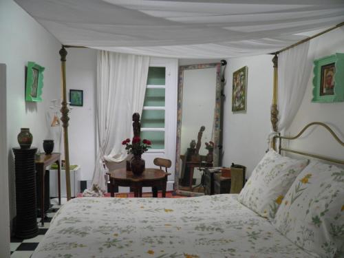 a bedroom with a bed and a table and a window at La Maison des Artistes in Essaouira
