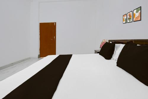 a bed with black and white sheets in a room at HOTEL O VATIKA & RESORTS in Lucknow