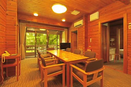 a wooden dining room with a wooden table and chairs at Karuizawa Prince Hotel West in Karuizawa