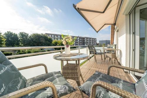 a balcony with chairs and a table on a balcony at Blankwasserweg 16- Sonnenseite in Grömitz