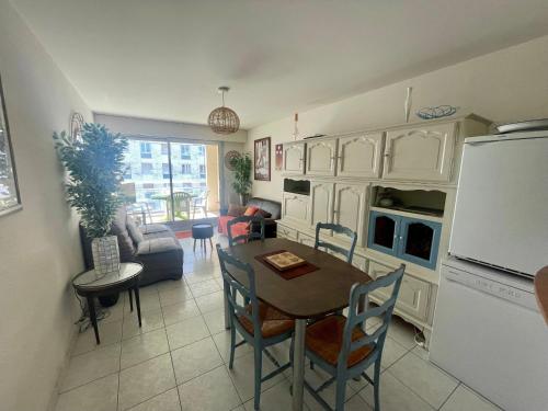 Il dispose d'une cuisine et d'un salon avec une table et un réfrigérateur. dans l'établissement Appartement T3 à 150m de la plage, proche centre, avec garage et loggia – Les Sables d'Olonne - FR-1-92-562, à Les Sables-dʼOlonne