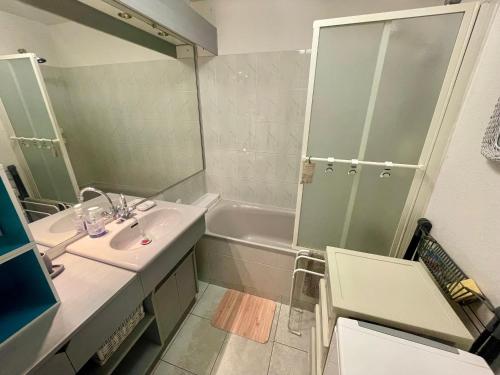 une salle de bain avec un lavabo, une douche et une baignoire dans l'établissement Appartement T3 à 150m de la plage, proche centre, avec garage et loggia – Les Sables d'Olonne - FR-1-92-562, à Les Sables-dʼOlonne