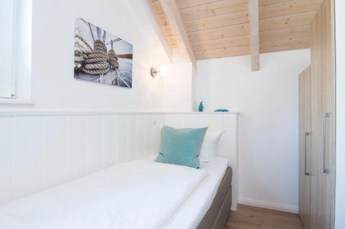 a white couch in a room with a picture on the wall at Seepark Süssau Ferienhaus Seehund 1 in Süssau