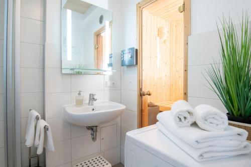 a white bathroom with a sink and a mirror at Seepark Süssau Ferienhaus Seehund 1 in Süssau