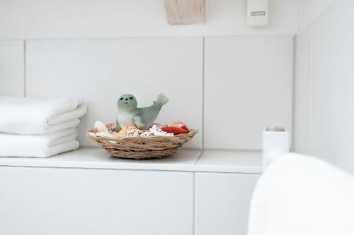 a toy frog sitting in a basket on a counter at Seepark Süssau Ferienhaus Seehund 1 in Süssau