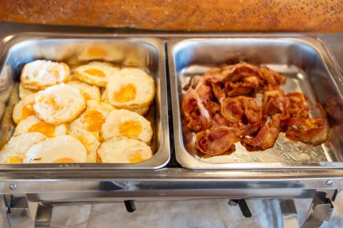 two trays of food with eggs and bacon at Lanta Riviera Beach Resort in Ko Lanta
