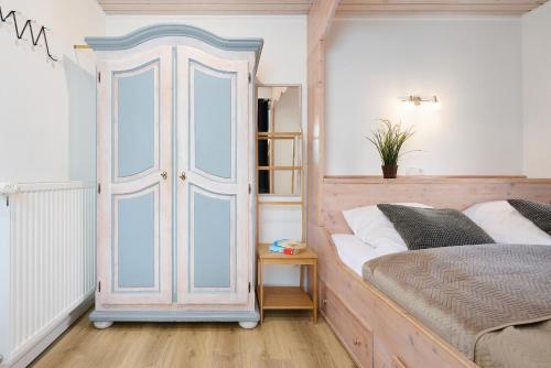 a bedroom with a bed and a white closet at Lütt Drosselhörn 2 in Laboe