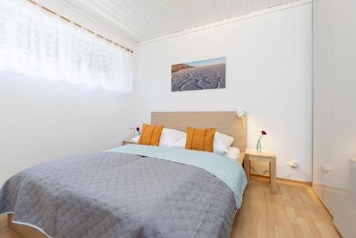 a white bedroom with a bed and a window at Blankwasserweg 131 Lensterstrand Oase Bungalow 6 in Lenste