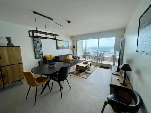 un salon avec une table et un canapé dans l'établissement T2 Lumineux Face Mer avec Terrasse et Garage - Quartier des Présidents, Proche Plage et Commerces - FR-1-92-900, à Les Sables-dʼOlonne