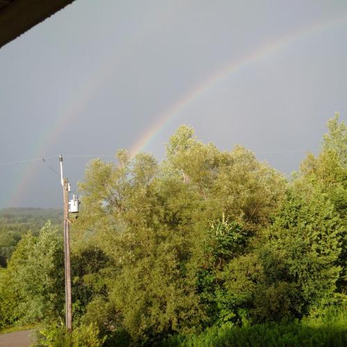 a rainbow in the sky over some trees at Our Valley View Bed & Breakfast in Hampton
