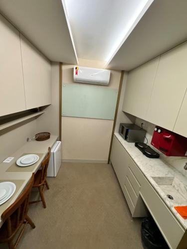 a small room with two tables and a kitchen at Espetacular - Flat no Jade Hotel Brasília in Brasília