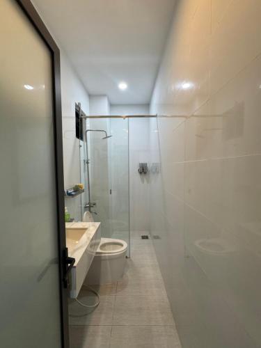 a bathroom with a toilet and a glass shower at Khách sạn Giang Thành, khu đô thị Tây Bắc, gần bến tàu đi Phú Quốc in Rach Gia