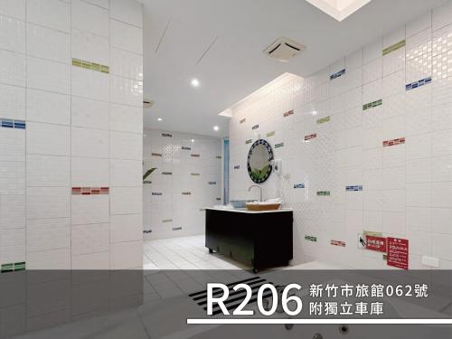 a bathroom with white tiled walls and a sink at CD Motel in Hsinchu City