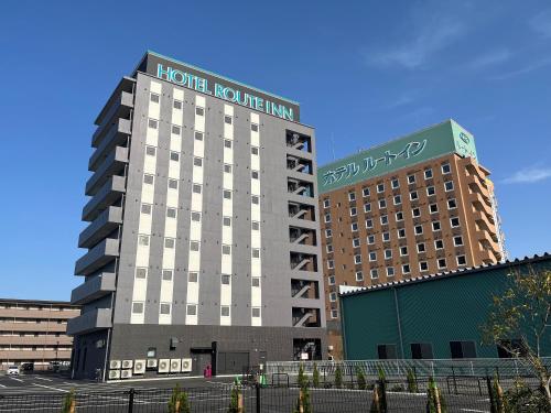 a hotel building with a sign on top of it at Hotel Route-Inn Nagahama Inter in Nagahama
