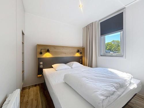 une chambre blanche avec un grand lit et une fenêtre dans l'établissement Mobil-home 4* Grand Confort, 200m plage, piscine, fitness, parking, ménage inclus, Wi-Fi gratuit - FR-1-361A-75, à Jullouville