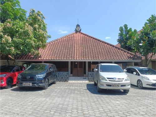 two cars parked in a parking lot in front of a house at Wisma Colomadu in Tjolomadu