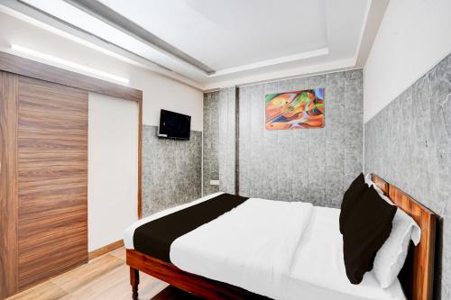 ガーズィヤーバードにあるHotel O Knights Innのベッドと壁掛けテレビのある寝室