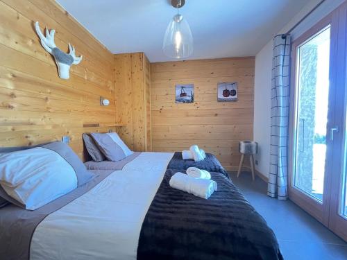 une chambre avec un lit avec deux serviettes dessus dans l'établissement Chalet de prestige 10 pers, proche pistes, Wifi, stationnement - FR-1-505-223, à Notre-Dame-de-Bellecombe