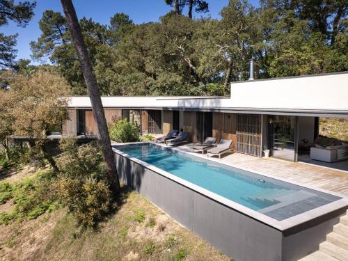 une vue extérieure d'une maison avec piscine dans l'établissement Villa de Luxe Contemporaine à Hossegor - FR-1-791-39, à Soorts-Hossegor