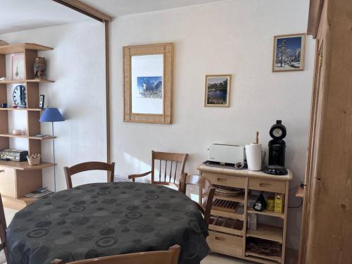 une salle à manger avec une table, des chaises et un miroir dans l'établissement Charmant appartement au centre avec balcon et parking - FR-1-812-135, à Cauterets