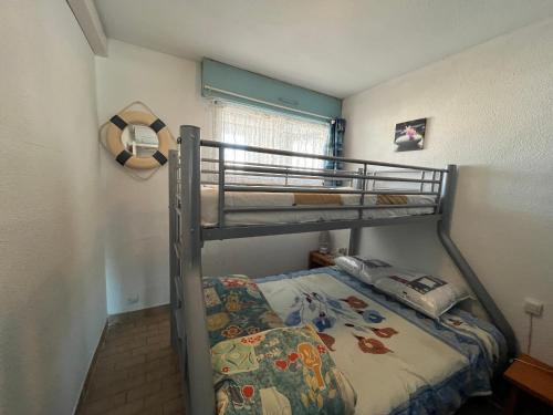 - une petite chambre avec des lits superposés et un couvre-lit dans l'établissement Charmant 2P à Sète avec parking privé, vue sur canal - FR-1-338-614, à Sète