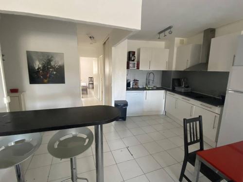 une cuisine avec des armoires blanches et un comptoir noir dans l'établissement Appartement 3 Pièces Moderne avec Loggia, 6 Personnes, Proche Plage - FR-1-750-82, à Canet