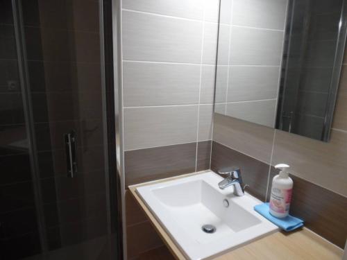 - un lavabo avec miroir et une bouteille de savon dans l'établissement Deux-pièces rénové en bord de mer avec parking privé - FR-1-750-83, à Canet