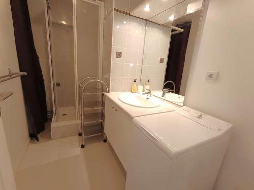 a white bathroom with a sink and a mirror at T2 cabine pour 4 pers, balcon, parking – Saint-Lary-Soulan - FR-1-457-379 in Saint-Lary-Soulan