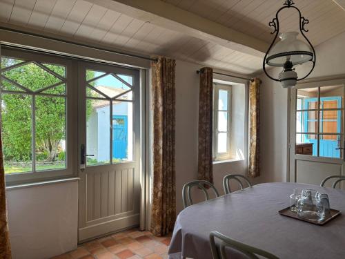 une salle à manger avec une table et une fenêtre dans l'établissement Maison noirmoutrine confortable pour 7 pers avec jardin et parking - FR-1-823-152, à Noirmoutier-en-l'lle