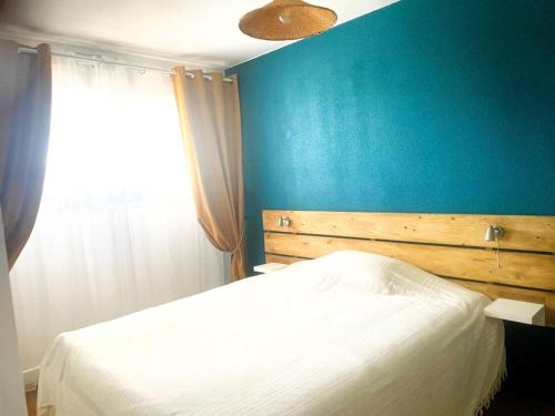 - une chambre avec un lit blanc et un mur bleu dans l'établissement La Grande Motte: Appart. 4 pers, Clim, Garage, Proche Plage - FR-1-790-34, à La Grande Motte
