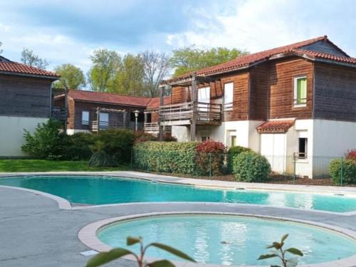 une maison avec une piscine devant une maison dans l'établissement Aureilhan - Appartement cosy 4 pers, à deux pas du lac - FR-1-50-174, à Aureilhan