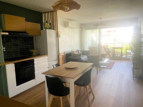 une cuisine et un salon avec une table et des chaises dans l'établissement La Grande Motte: Appart. 4 pers, Clim, Garage, Proche Plage - FR-1-790-34, à La Grande Motte