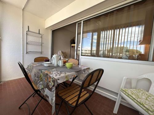 une table et des chaises dans une pièce avec une fenêtre dans l'établissement Studio cabine à Port Camargue, accès plage 4 pers - FR-1-250-308, au Grau-du-Roi