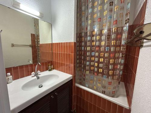 une salle de bain avec un lavabo et un rideau de douche dans l'établissement Studio cabine à Port Camargue, accès plage 4 pers - FR-1-250-308, au Grau-du-Roi