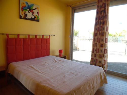 une chambre avec un lit et une grande fenêtre dans l'établissement Appartement T2 calme avec terrasse et parking - 400m de la plage - FR-1-750-85, à Canet