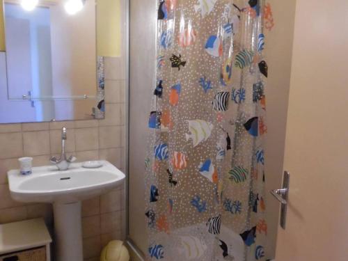 une salle de bain avec un rideau de douche et un lavabo dans l'établissement Appartement T2 calme avec terrasse et parking - 400m de la plage - FR-1-750-85, à Canet