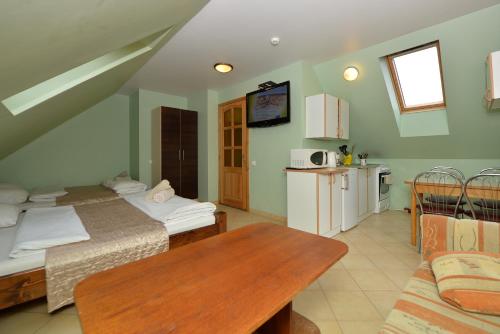 a room with two beds and a table and a kitchen at Karkle Beach Apartments in Karklė
