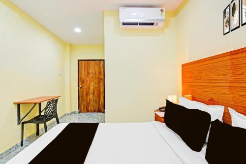 a hotel room with a bed and a desk and a television at Super Hotel O Madlen in Hyderabad