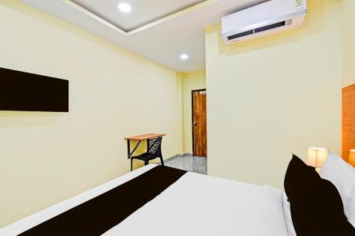 a bedroom with a bed and a tv on the wall at Super Hotel O Madlen in Hyderabad