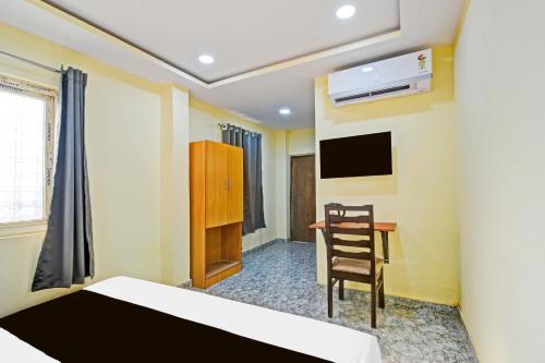 a bedroom with a bed and a chair and a desk at Super Hotel O Madlen in Hyderabad