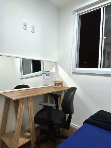 a desk with a mirror and a chair in a room at Apartamento aconchegante e moderno com varanda na Rua Guaicurus in Sao Paulo