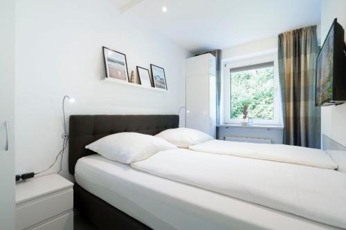two beds in a bedroom with a window at Haus Meeresgruß Ostseebrise in Grömitz