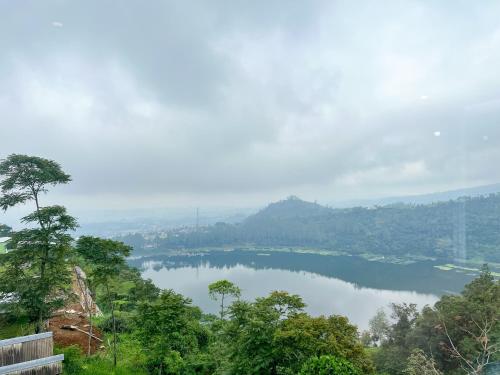 a view of a lake from a hill with trees at Urbanview Hotels Asmaraloka Umbrella in Kejajar