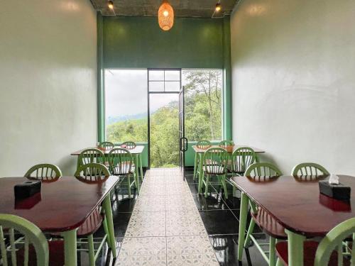 a room with tables and chairs and a large window at Urbanview Hotels Asmaraloka Umbrella in Kejajar